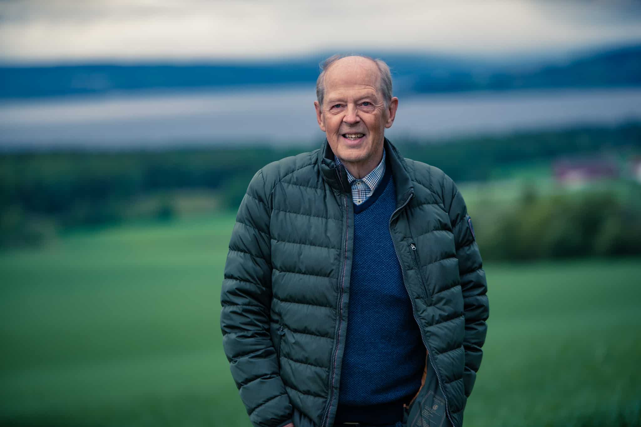 Øyvind Fjellestad i et grønt landskap med fjorden i bakgrunnen